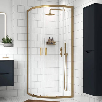 Easily create your dream shower enclosure with an easy to buy enclosure & tray bundle from BathLab.co.uk. Image shows a brushed brass quadrant shower on a white stone resin shower tray in a modern white bathroom.