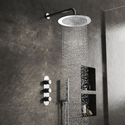 Chrome overhead shower with wall arm and handset on a dark tiled wall