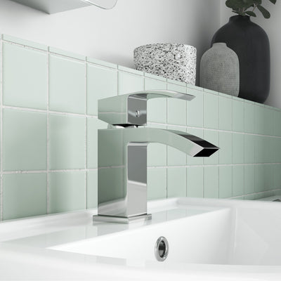 Como Basin Mixer Tap With Push Open Waste, shown on a white basin with a green tiled background